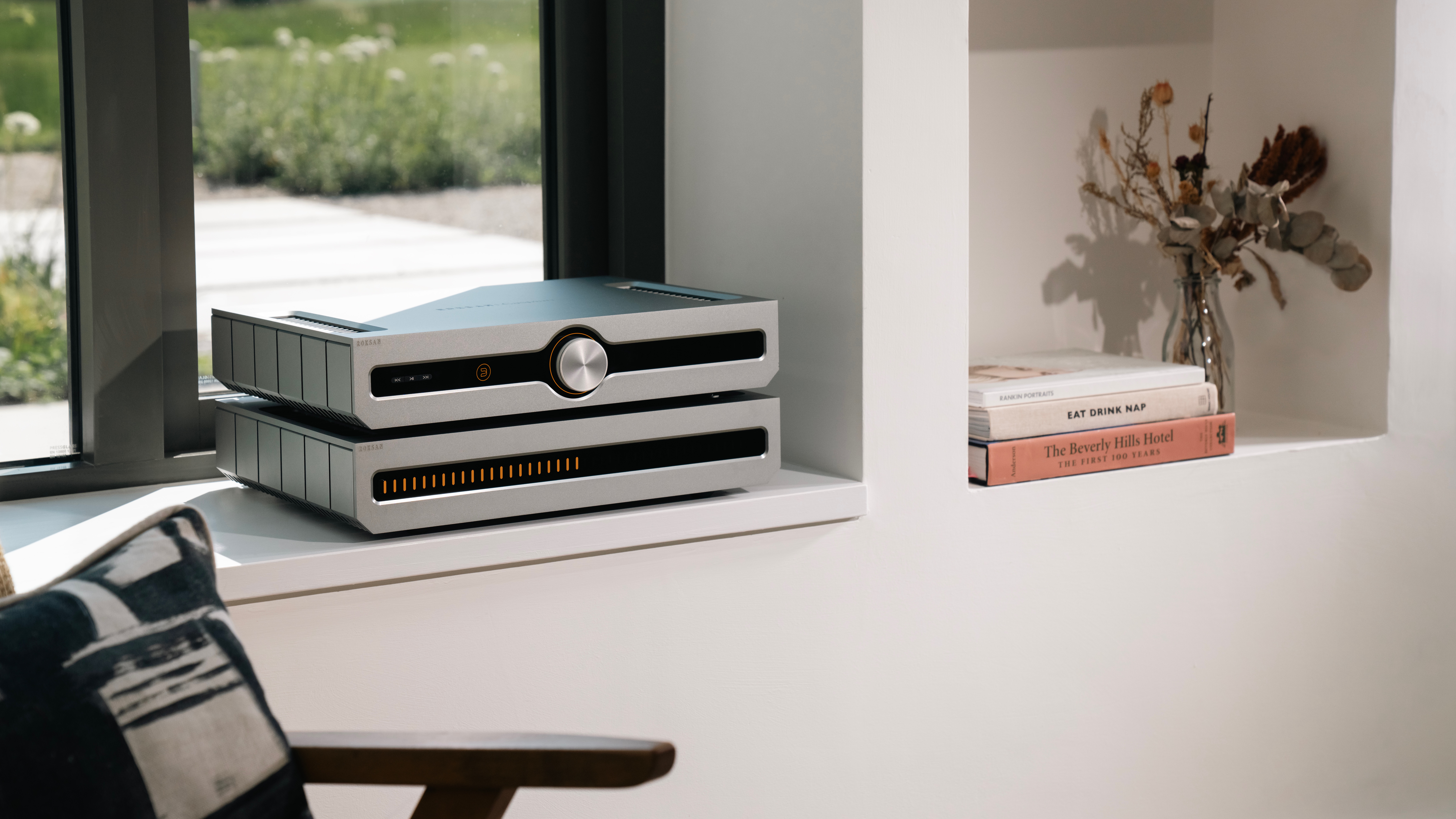 Roksan Caspian Streaming Pre-Amplifier and Power Amplifier sitting on a window shelf in what looks like a home office