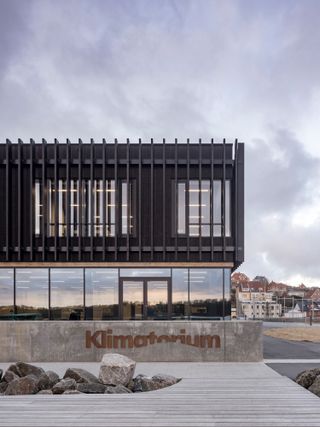 The entrance of the Lemvig Klimatorium is clad in timber as the building sits on a concrete plinth