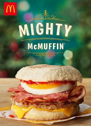 The Mighty McMuffin at McDonald's - a picture of a bun with egg, bacon, sausage and cheese/ with the words 'Might McMuffin'