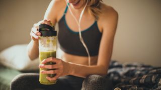 Woman holding a smoothie post-workout: diet and metabolism