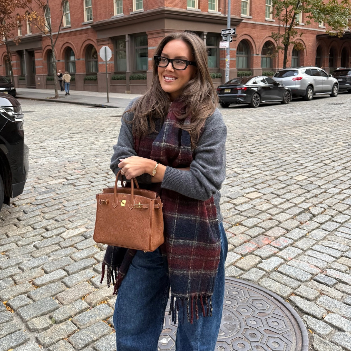 Emma Leger in a grey sweater and plaid scarf