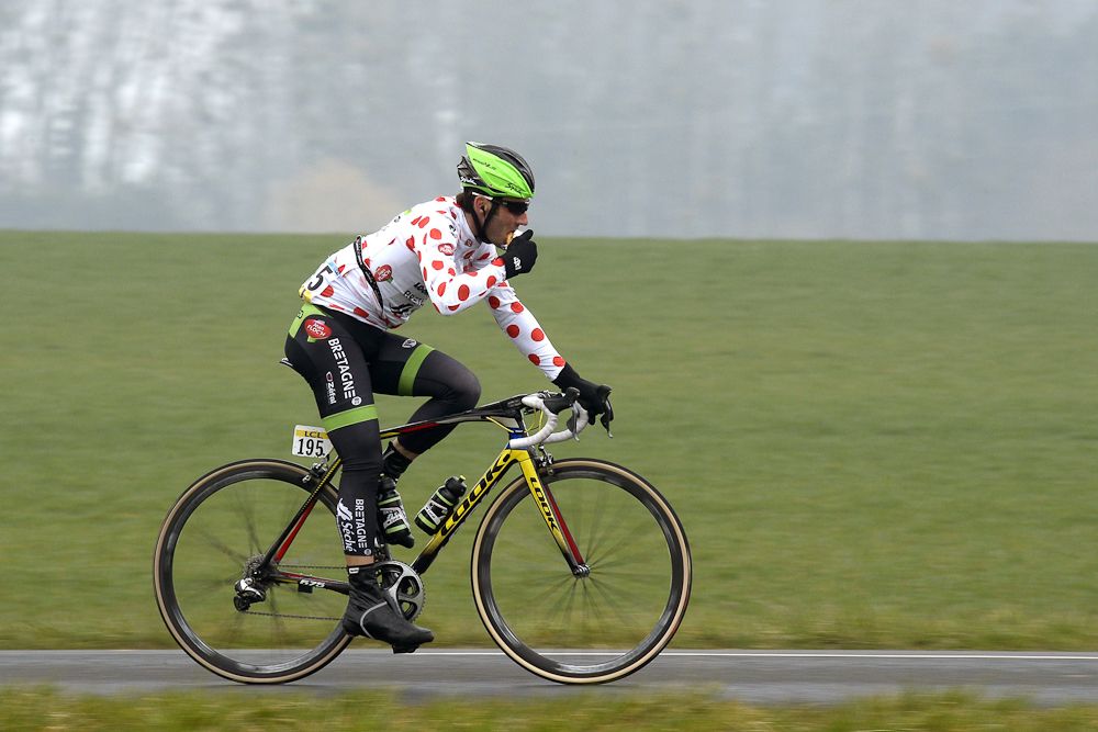France's Jonathan Hivert, wearing the best climber's polka dot jersey, eats as he rides in the pack.