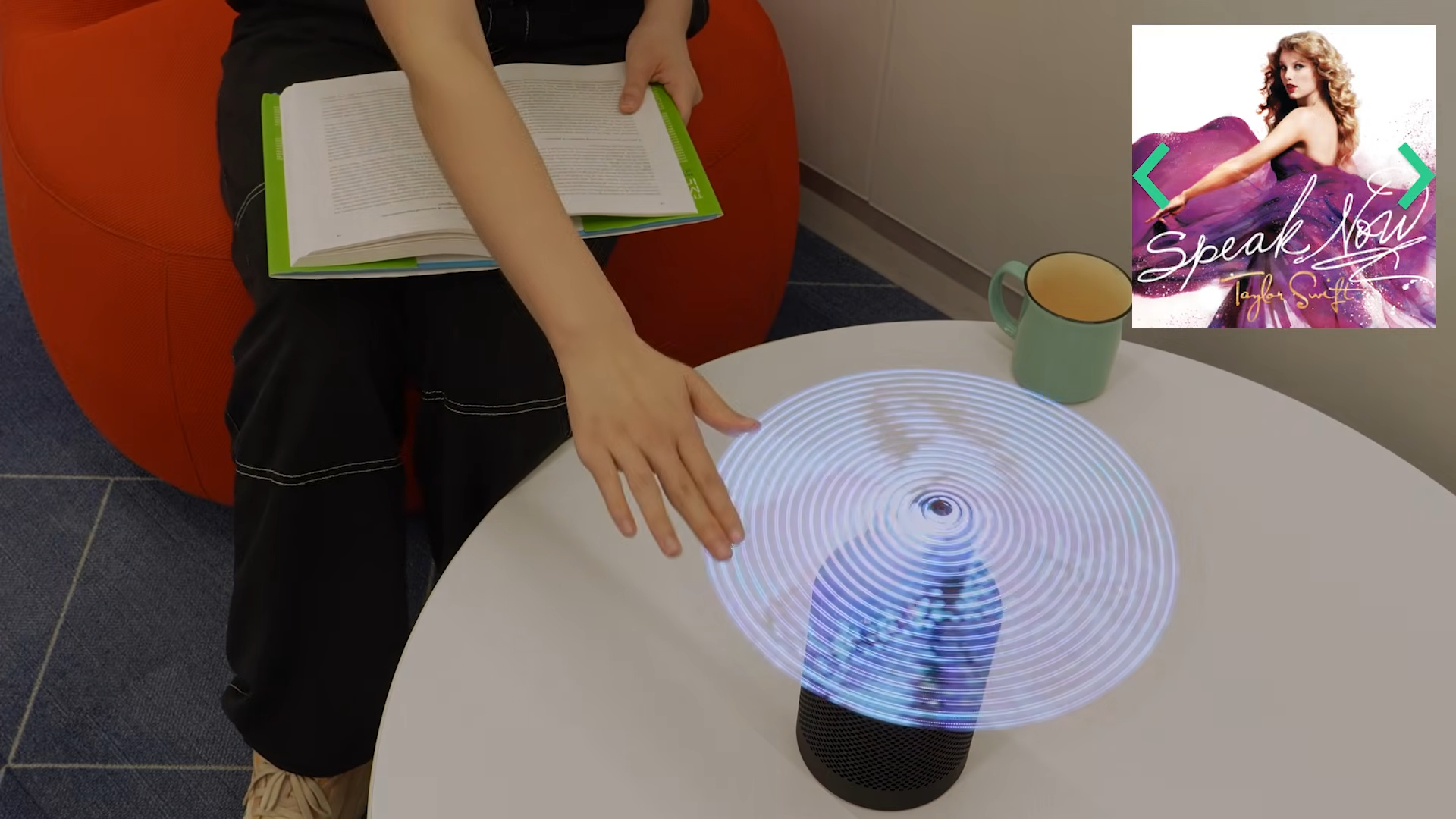 A person touches a capacative, hologram fan display to skip between music tracks.