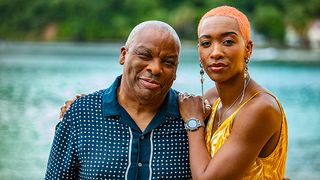 Commissioner Selwyn (Don Warrington) and Andrina Harper (Genesis Lynea) hugging for Death in Paradise