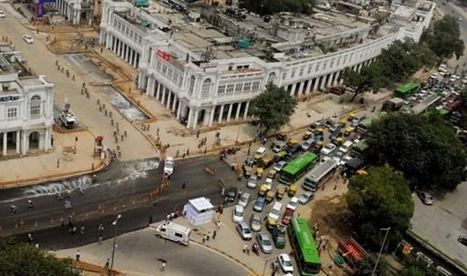 Traffic and commuters are seen stuck at an intersection as cyclists (L) ride in a pack through Connaught Place in New Delhi.