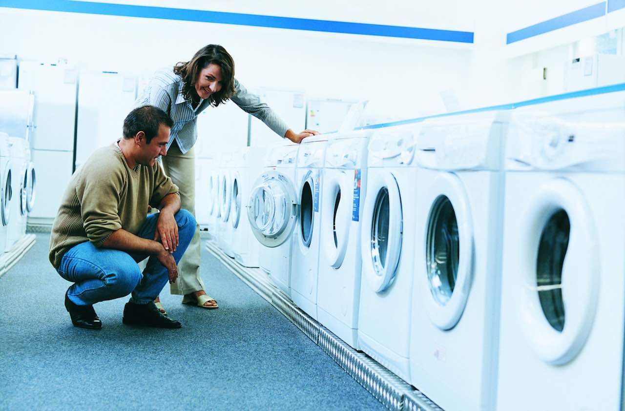 Couple Looking at a Washing Machine in An Aisle of a Department Store