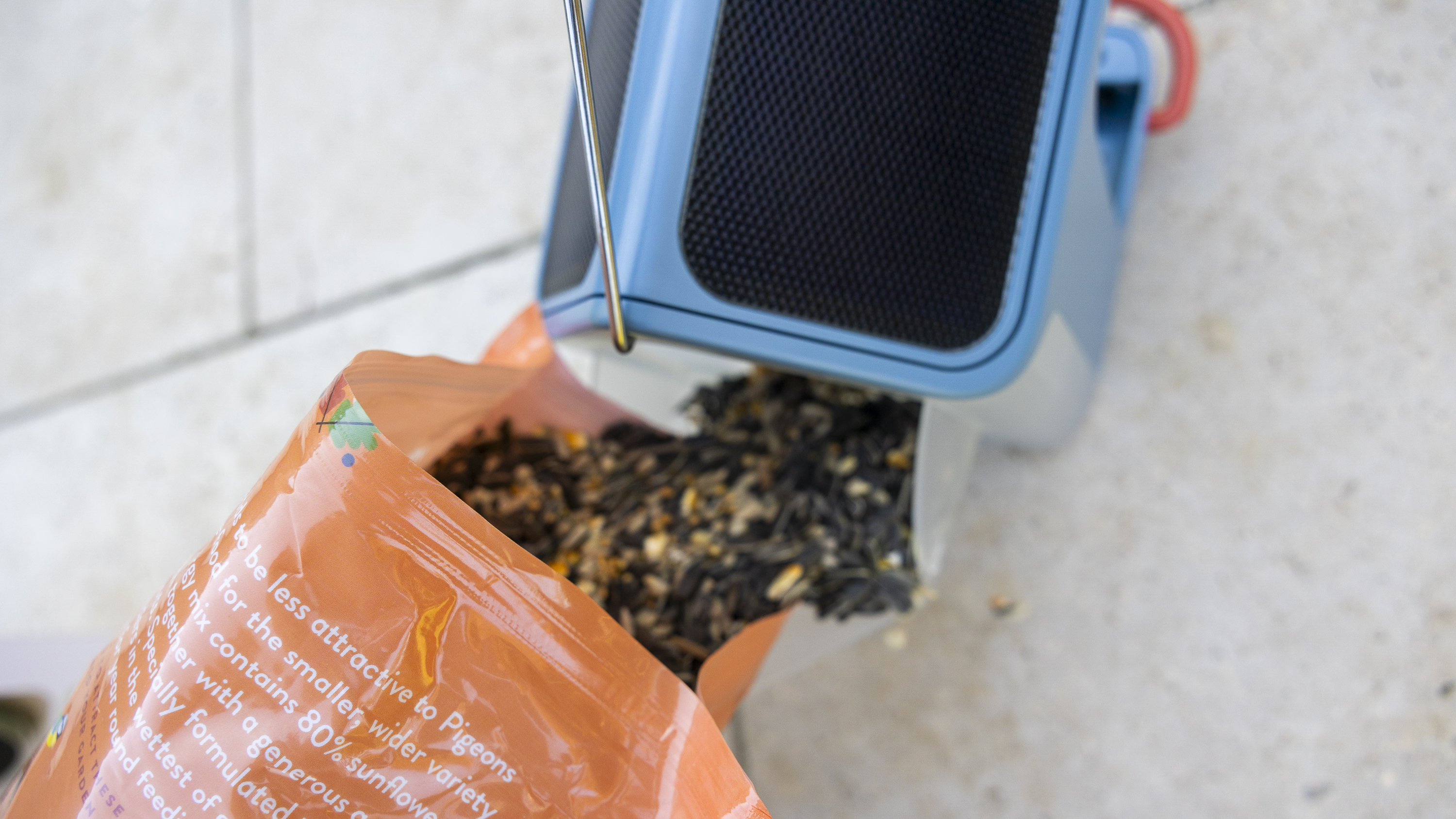 The Bird Buddy 2 feeder being filled with seed