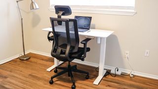 A laptop on a standing desk without a cable management tray