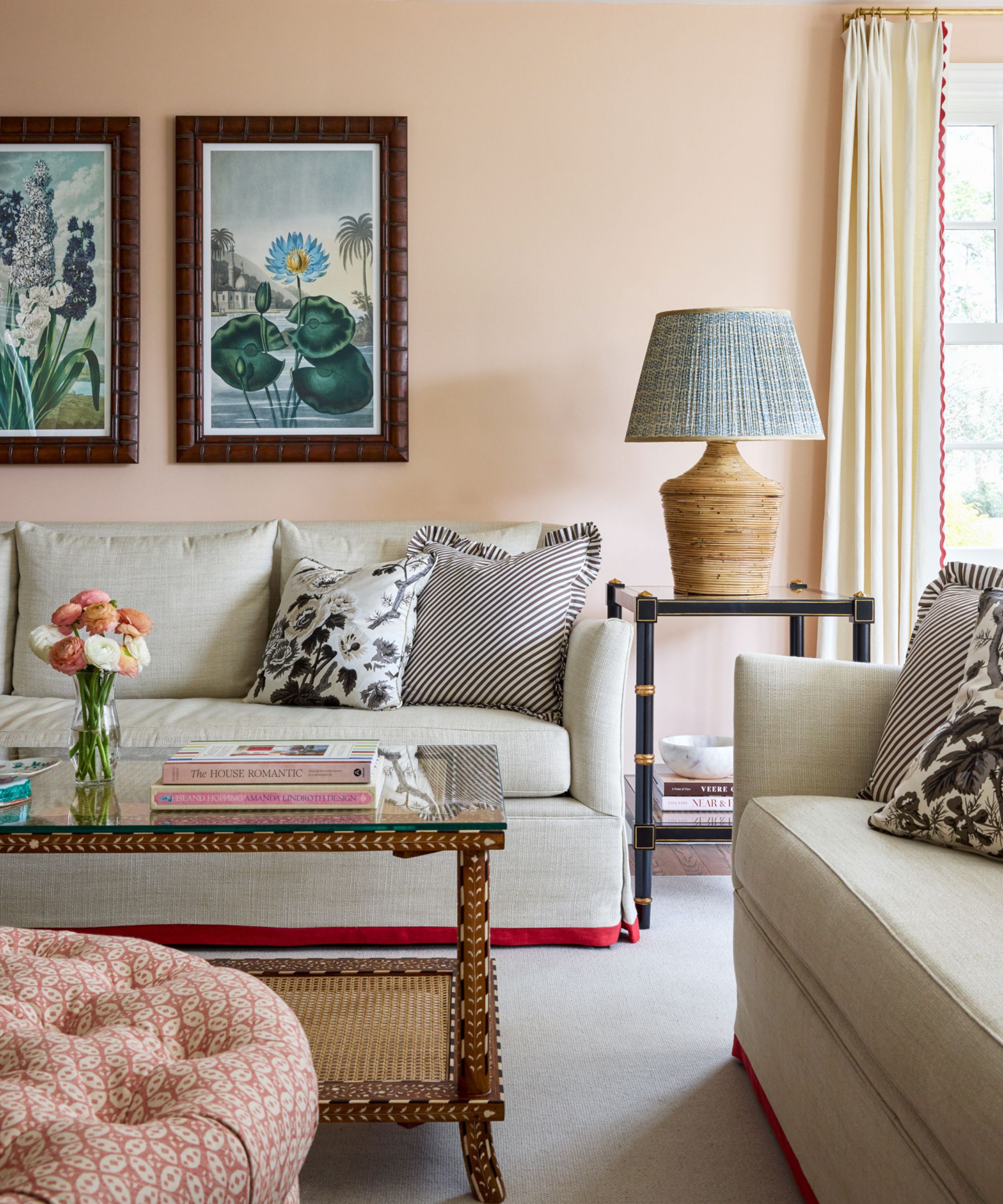 Living room in Aristocrat Peach by Sherwin Williams with traditional beige sofas and botanical wall art