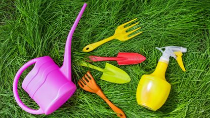 Bright plastic garden tools on grass