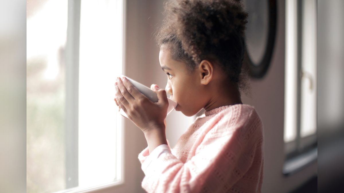 A girl drinks from a mug