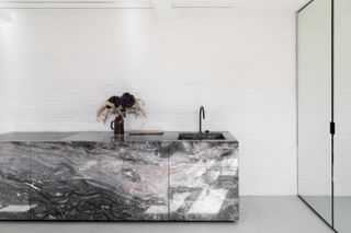 Grenelle flat by Studio Vincent Eschalier focussing on a marble kitchen against a wall.