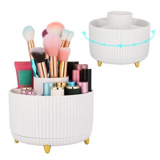 A white scalloped rotating makeup brush holder with gold feet