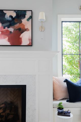 bedroom or living room space with picture TV mounted above fireplace, window seat