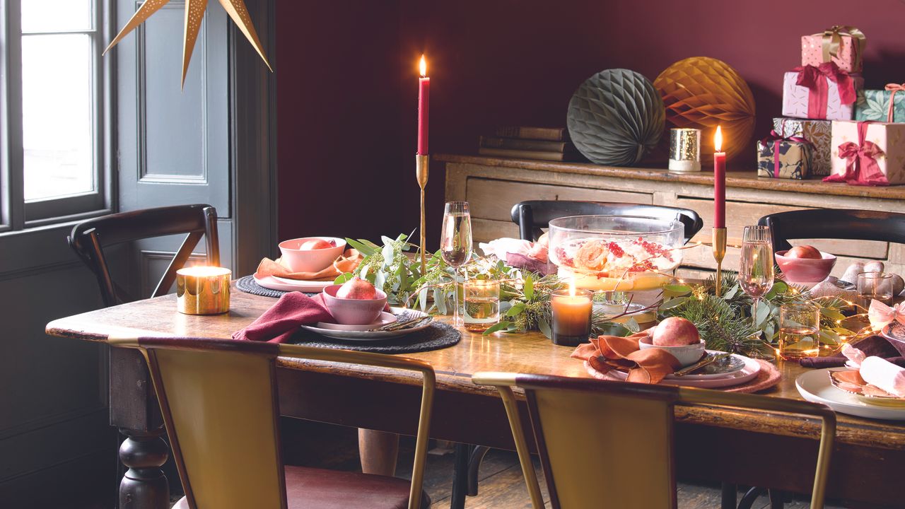 Christmas tablescape with red decorations on a wooden table.