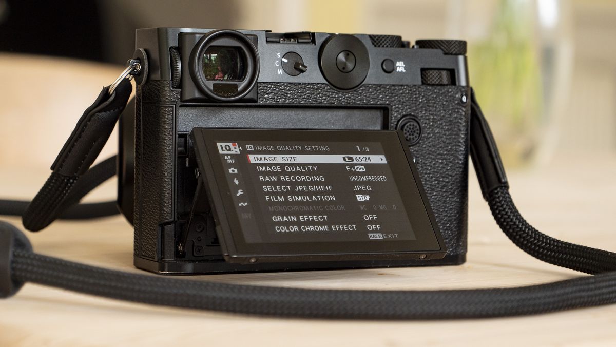 All-black Fujifilm GFX100RF rangefinder-style camera on a wooden table