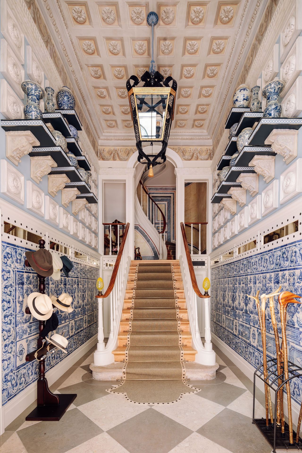 Blue print wallpaper, grey and white tiled floor and stair rug