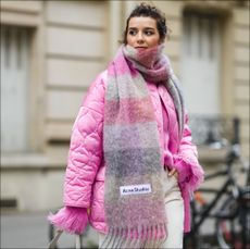 woman wears pink wool blanket scarf