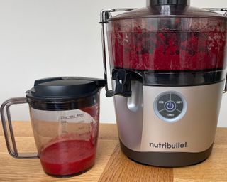 Making fresh raspberry juice in the Nutribullet Pro on wooden dining table