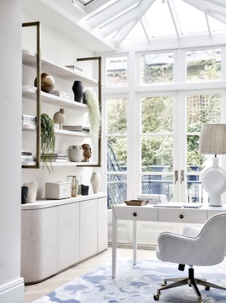 white home office with houseplants and views to the garden