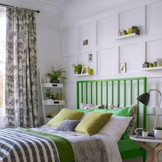 bedroom with white wall ans shelf green bed with designed cushions