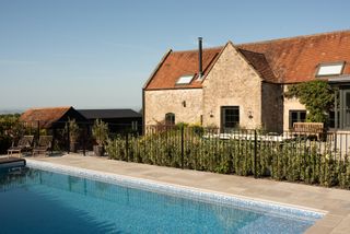a swimming pool installed outside of a converted barn