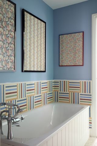 Small bathroom tile ideas A blue bathroom with multicoloured tile splashback around the bath