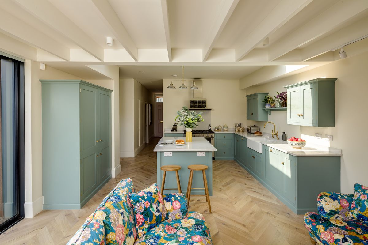 blue kitchen with wooden herringbone floor