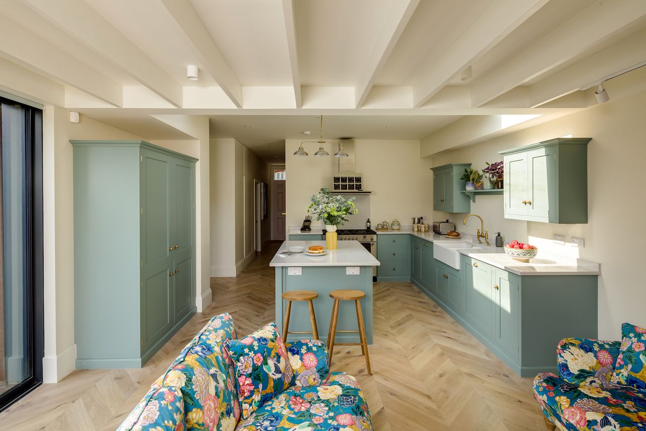 blue kitchen with wooden herringbone floor