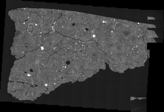 An image of a piece of the Antarctic meteorite Asuka 12236 as seen through a microscope; the sample is about 0.3 inches (1 centimeter) across.