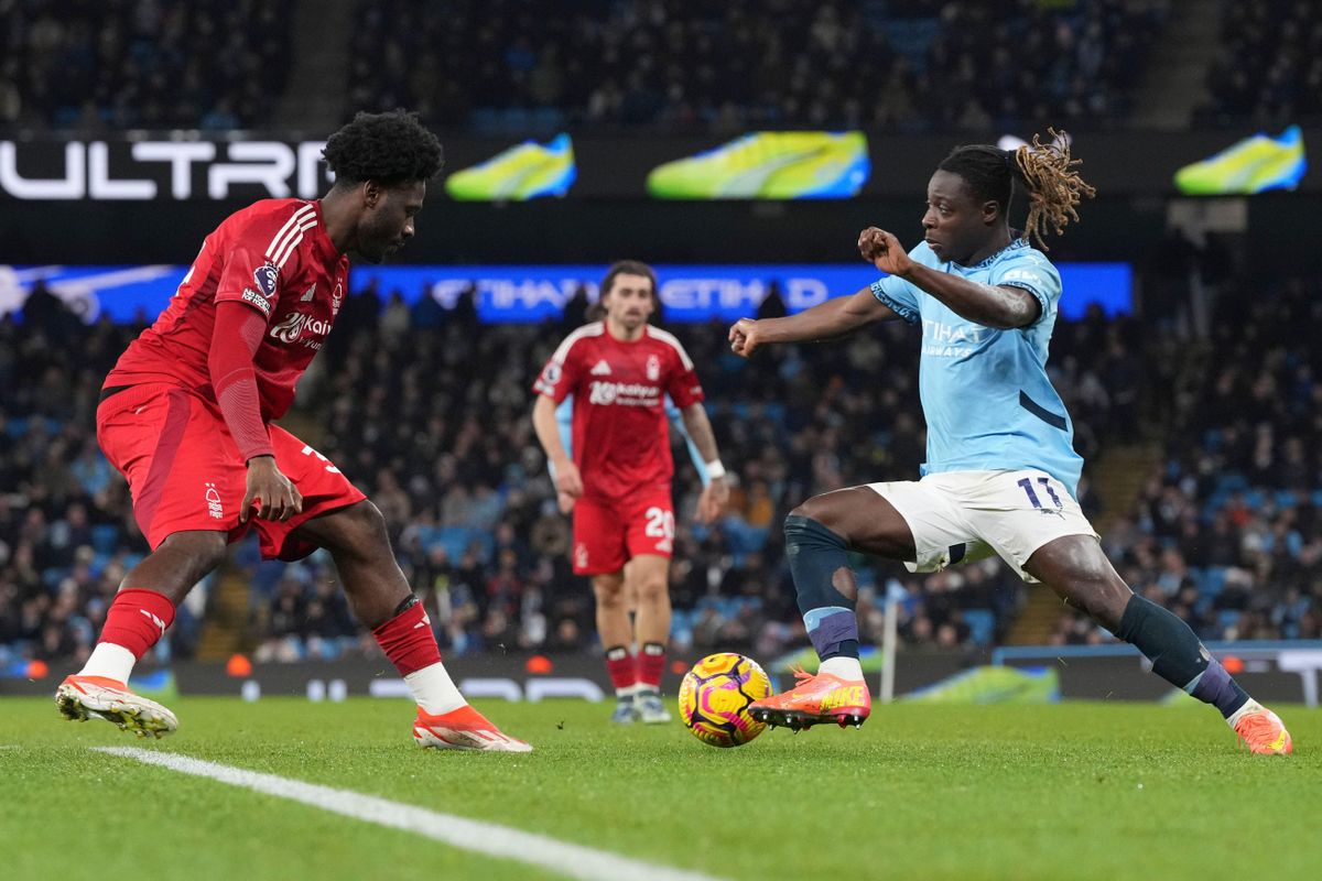 Manchester City&#039;s Jeremy Doku takes on Nottingham Forest&#039;s Ola Aina during the Premier League match at the Etihad Stadium in Manchester on 4 December, 2024