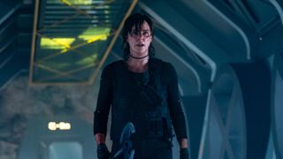 Charlize Theron cutup and holding an ax in The Old Guard 2