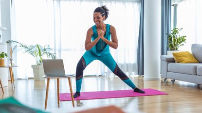 Woman doing exercise in front of a laptop