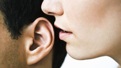Woman whispering in a man's ear