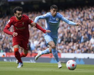 Mohamed Salah tussles for the ball with Joao Cancelo