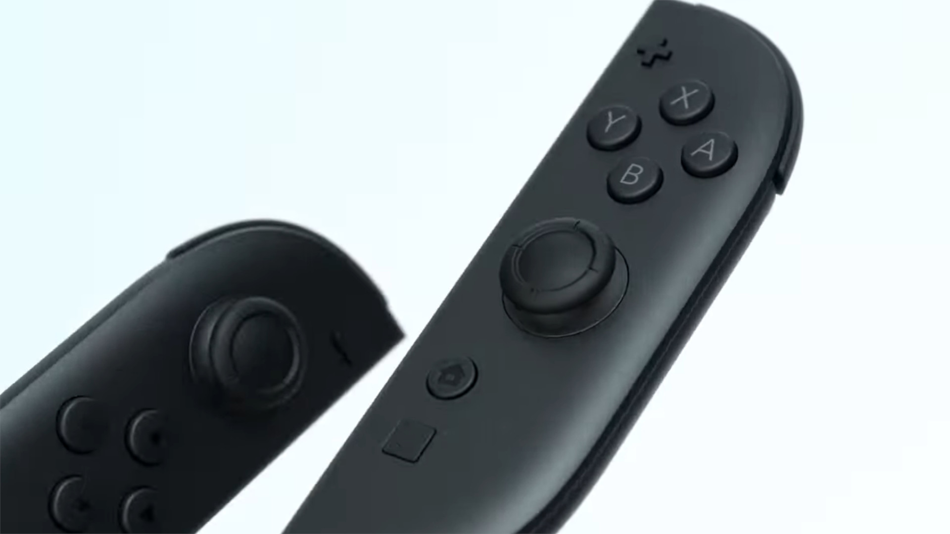 Nuevo Nintendo Switch 2 Joy-Cons sobre fondo blanco. Son negros con algunos puntos de colores alrededor de las palancas y hay un nuevo botón debajo del botón de inicio.