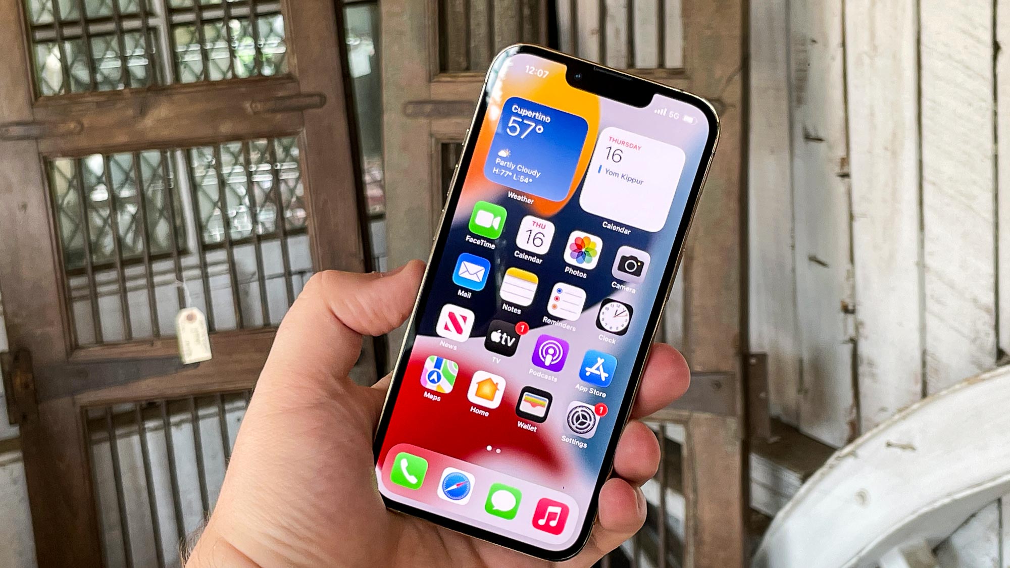 iphone 13 pro display on in hand with metal background