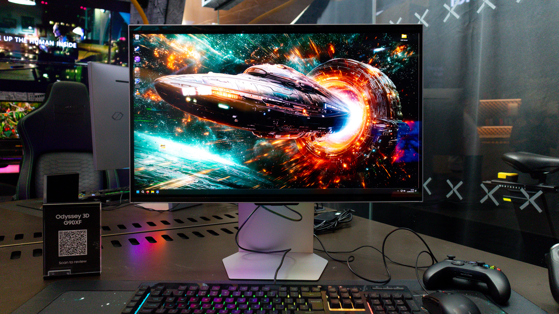 Samsung Odyssey 3D monitor on a desktop with keyboard, Xbox controller and other gaming accessories