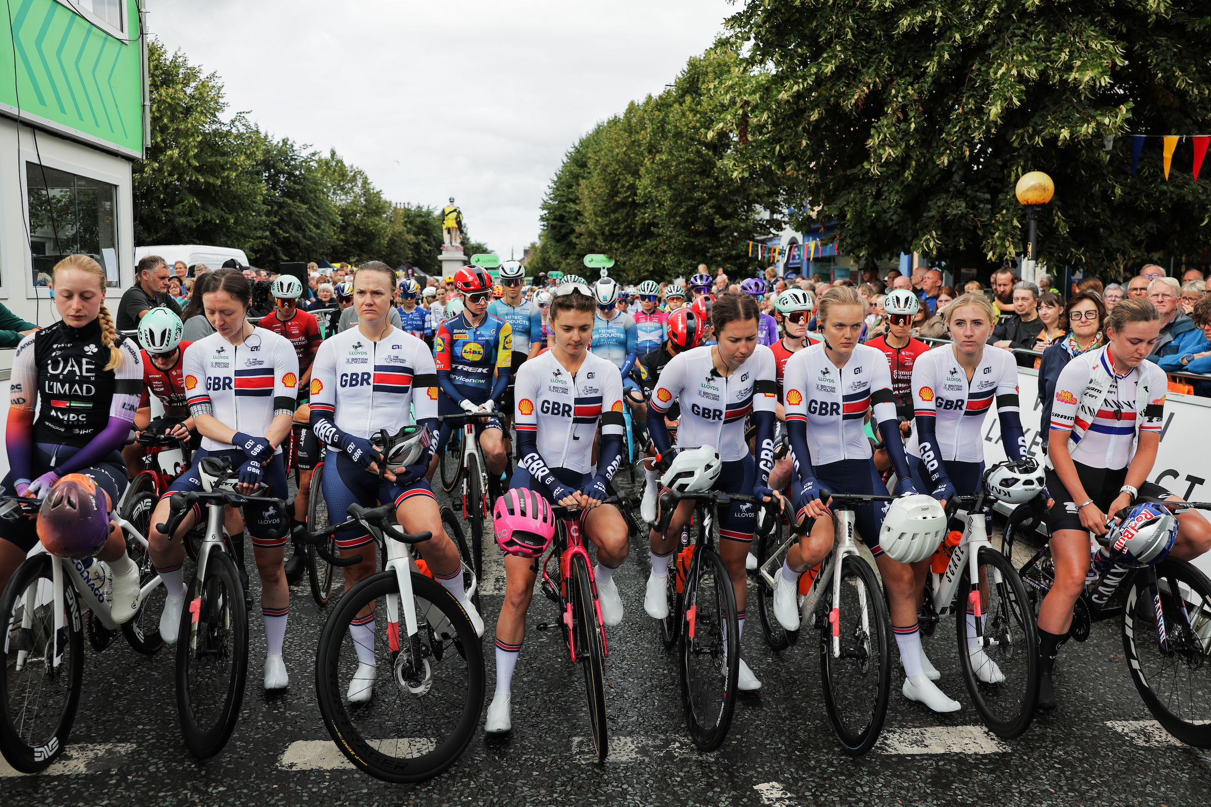 Riders at the Tour of Britain Women in a moment of reflection for Finlay Tarling