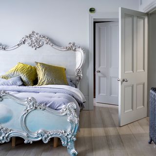 bedroom with wooden floor and white door and glamour pillows