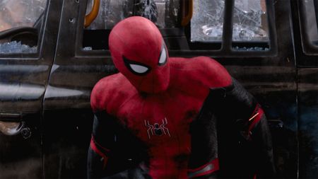 Spider-Man (Tom Holland) hides behind a car in Spider-Man: Far From Home