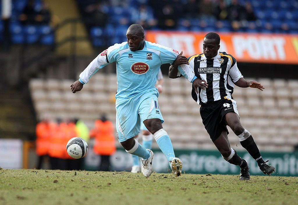Adebayo Akinfenwa of Northampton Town attempts to move away from the challenge of Anthony Griffith of Port Vale during the Coca Cola League Two Match between Port Vale and Northampton Town at Vale Park on March 6, 2010 in Stoke on Trent, England.