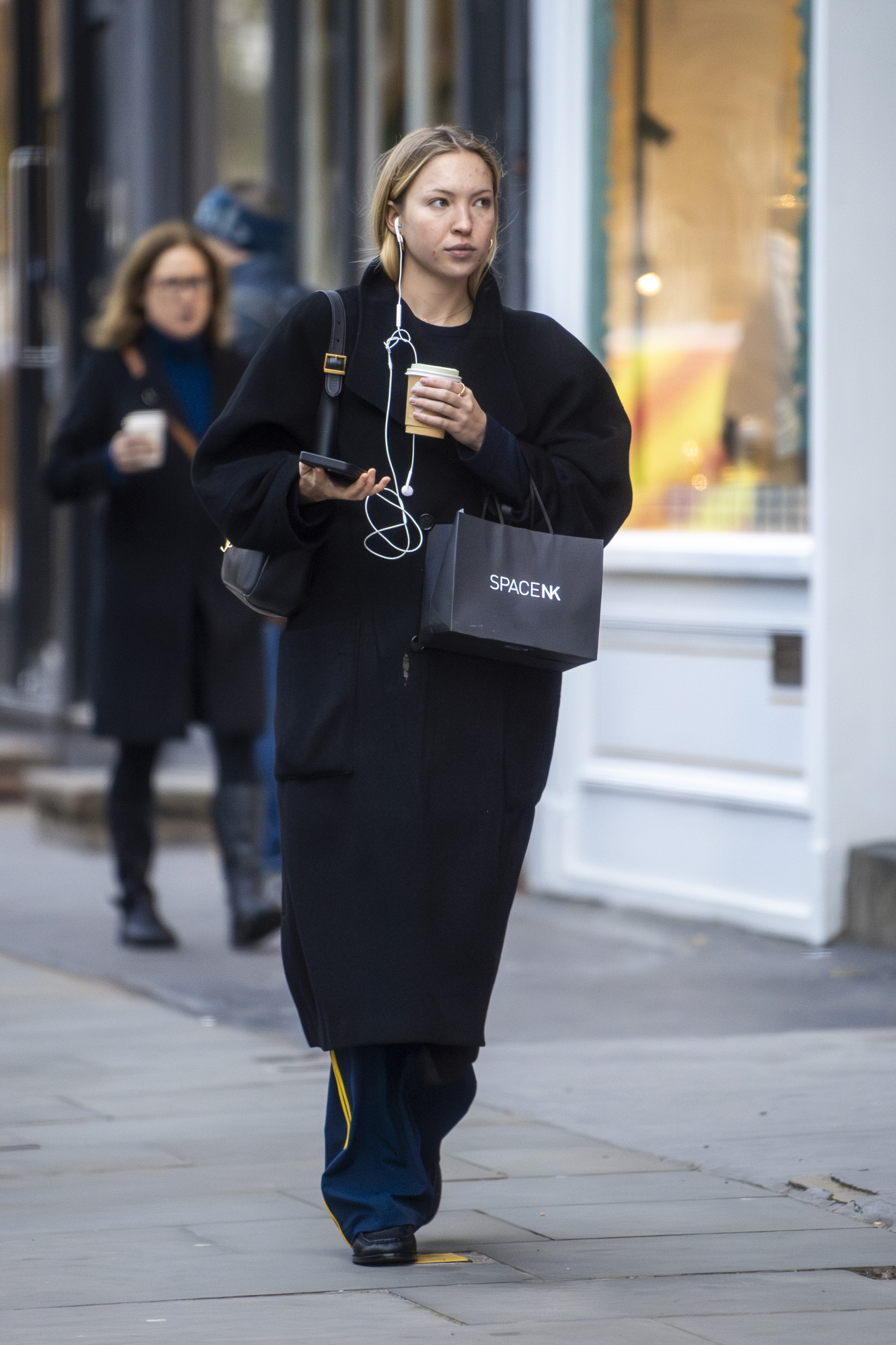 Lila Moss is seen doing some shopping in Notting Hill with a coffee. The English fashion model wore a long black coat over denim jeans and a Saint Laurent bag.