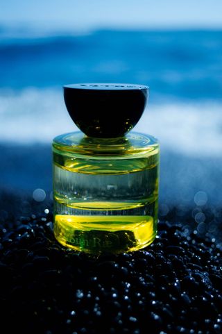 Vyrao Sun Rae perfume bottle on the beach