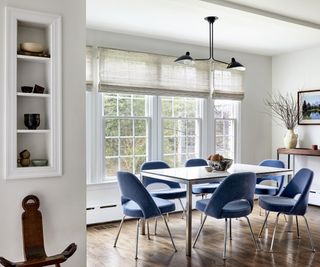 eat-in kitchen with blue chairs, white table and large windows