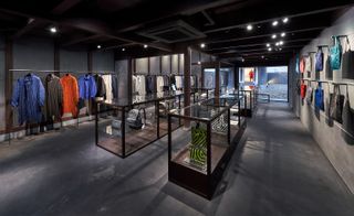 Interior of the store featuring clothing hanging on rails and accessories displayed in glass cabinets
