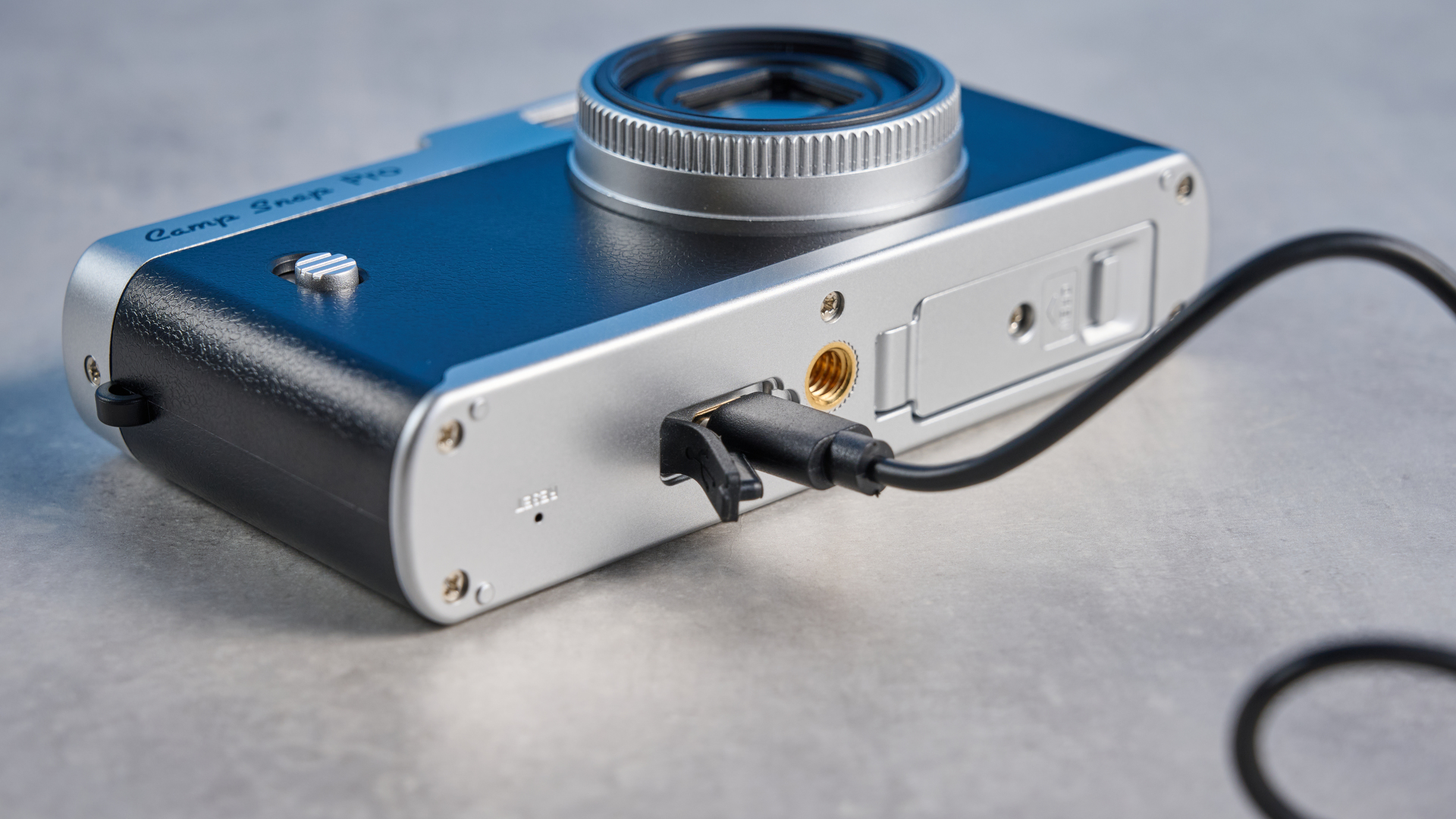 Camp Snap CS-Pro in black and silver photographed on a blue background