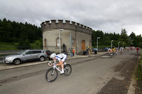 Riders pass in front of one of two city water service reservoirs in Mt. Tabor park.