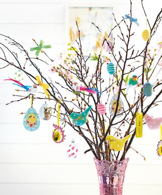 Blossom twig tree with hanging Easter decorations in pink vase