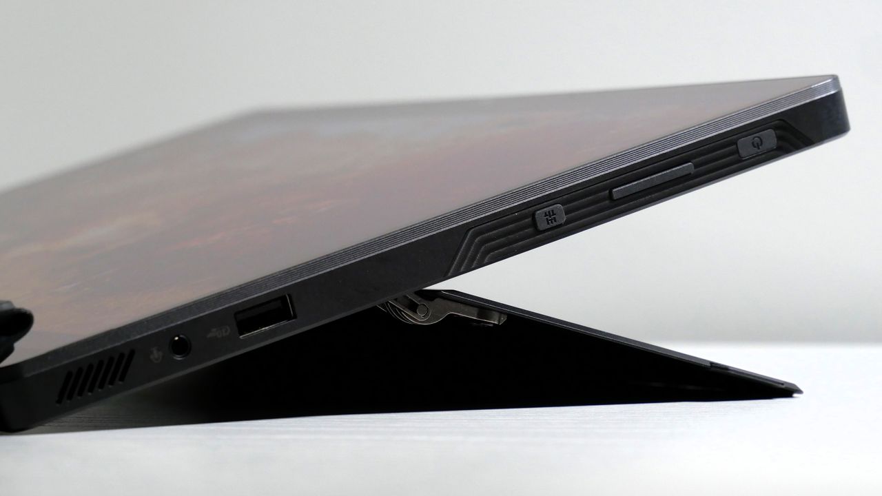 Asus ROG Flow Z13 (2025) with its kickstand extended, highlighting the ports on the right side, including a USB Type-A, headphone jack, and buttons for volume, power, and quick settings.